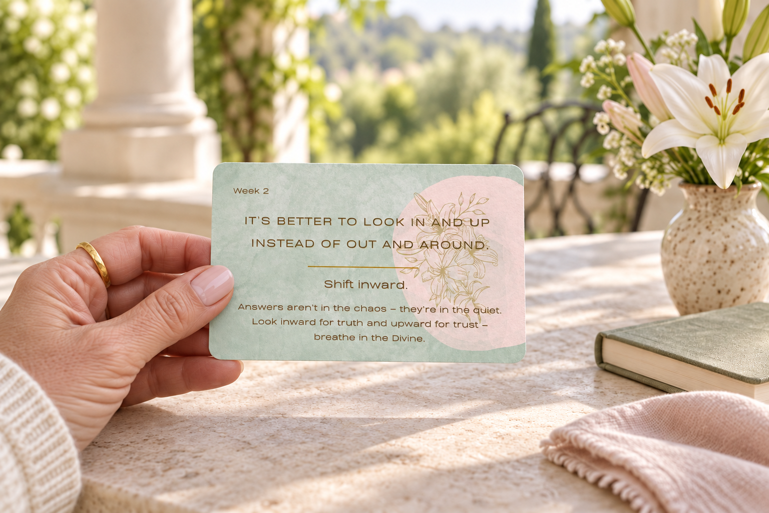 A person holding the Week 2 Steady Center card in a peaceful garden setting